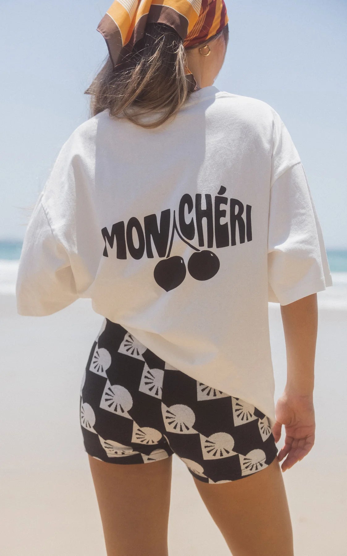 White tee with black motif on back saying Mon Cheri